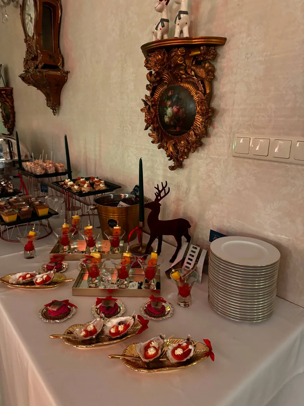 Linia bufetowa z kanapkami, finger food i deserami w świątecznej aranżacji willi
