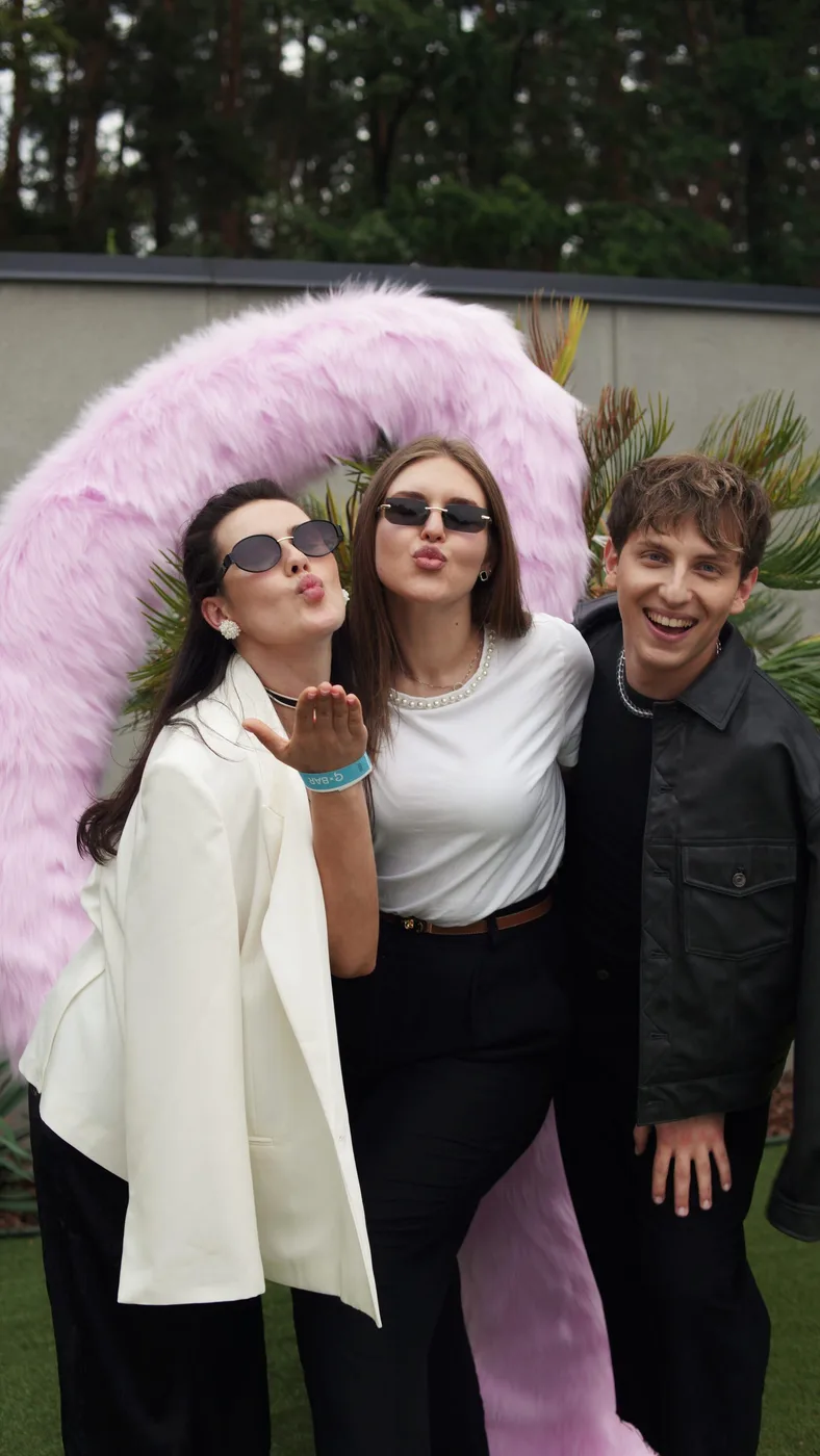 Guests at the photo zone with a fluffy pink letter G