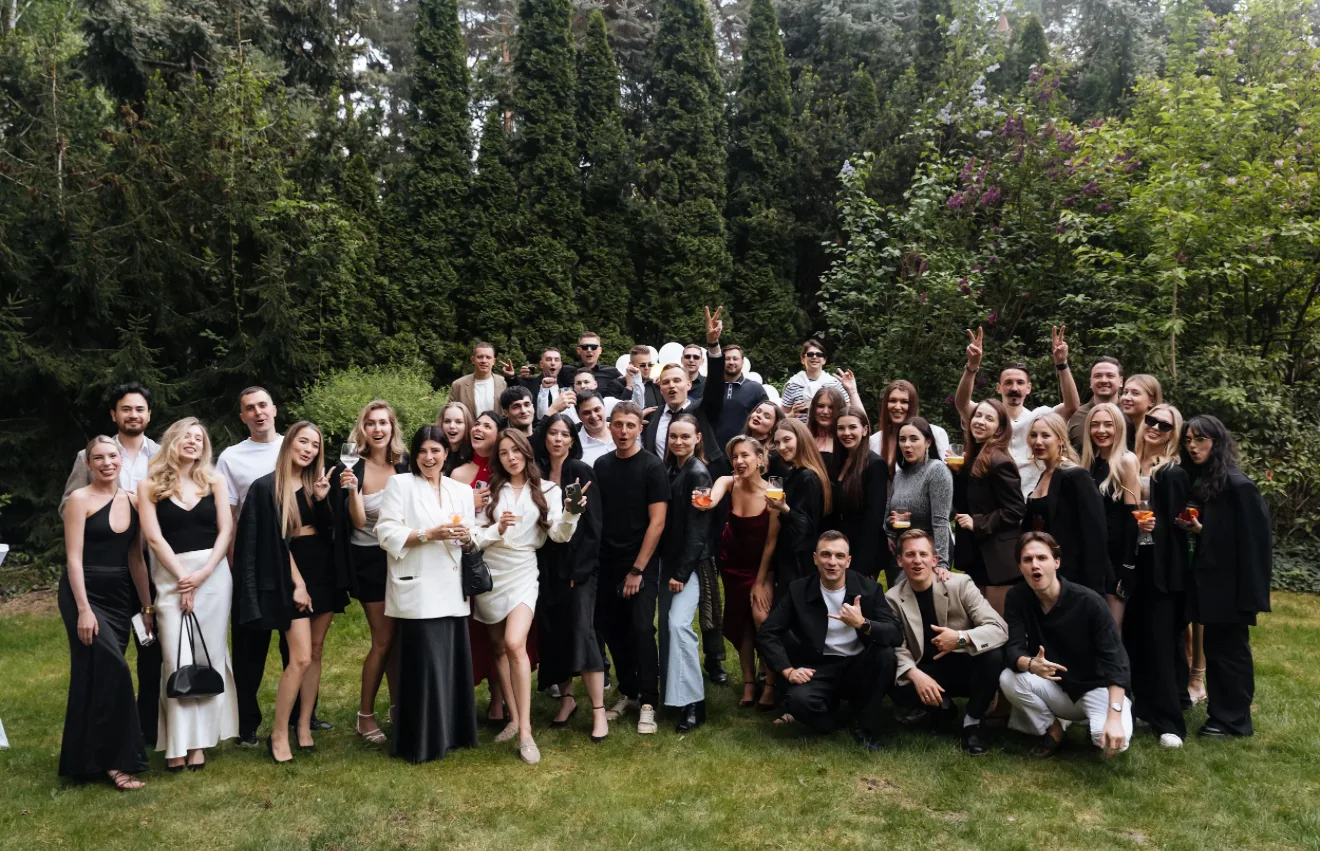 A group photo of more than 40 guests in the garden of a country house