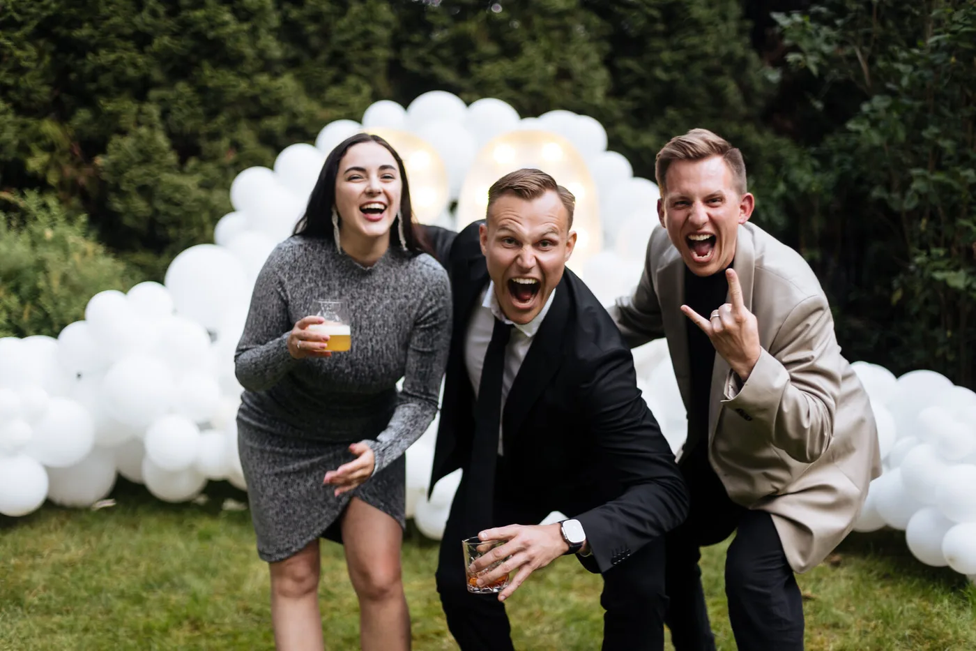 Guests celebrating beside a photo zone made of white balloons