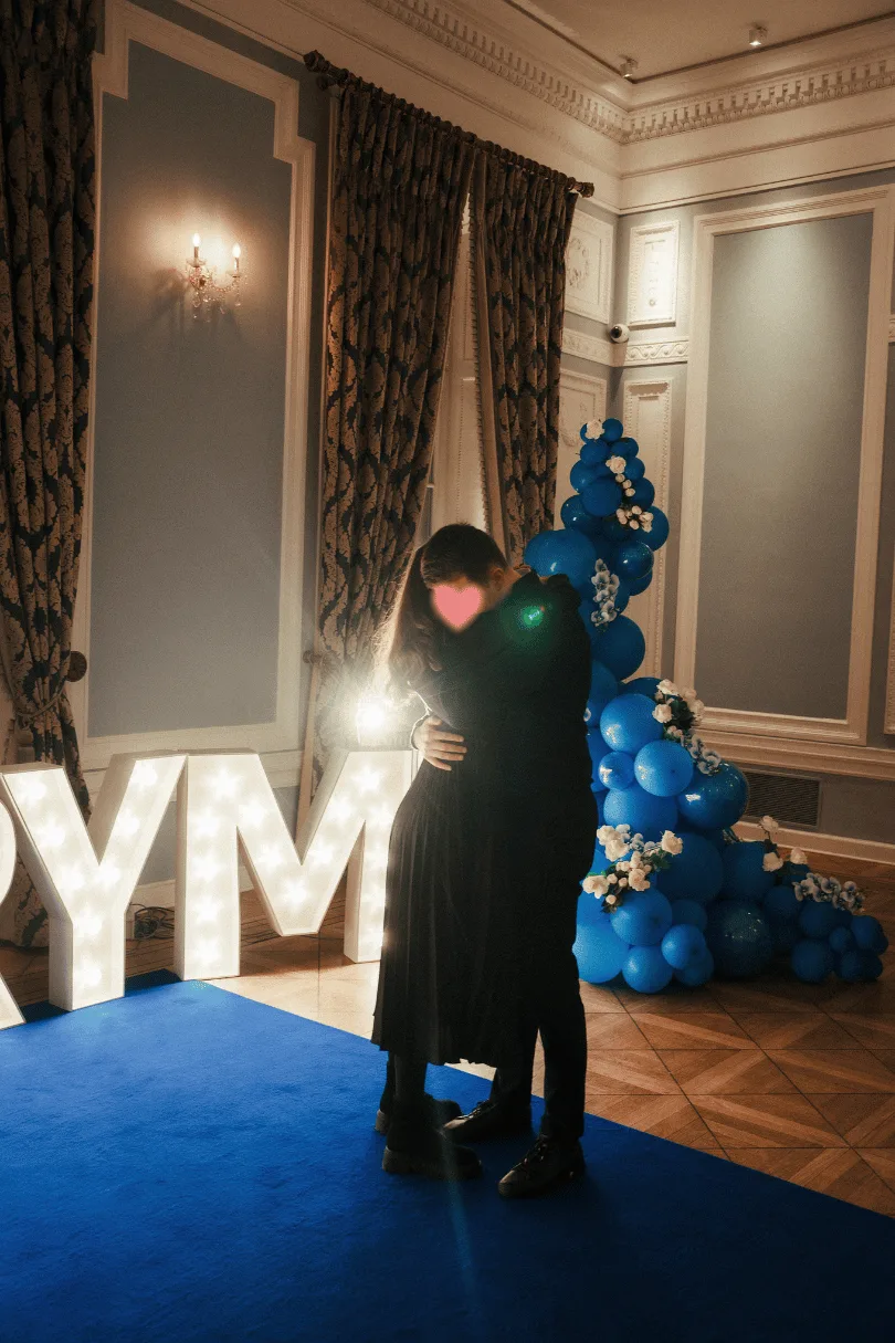 A couple embracing in a romantic hall arrangement with flowers and light