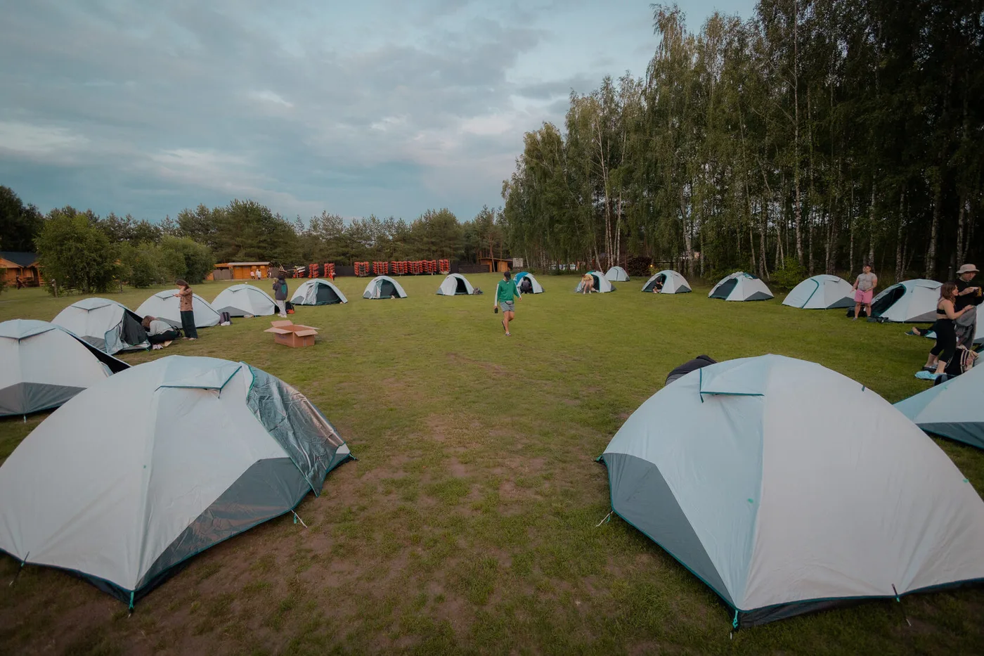 The camp's tent zone with dozens of tents on a clearing beside the forest
