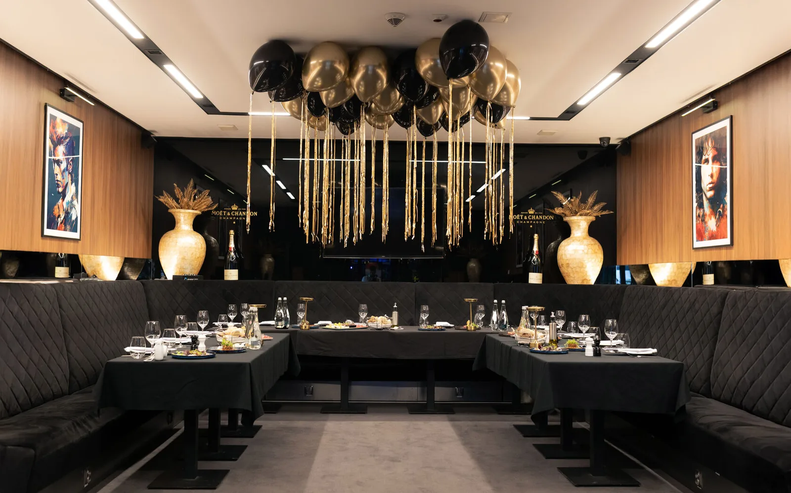 The STIXX restaurant room in a black-and-gold setting with banquet tables and balloons