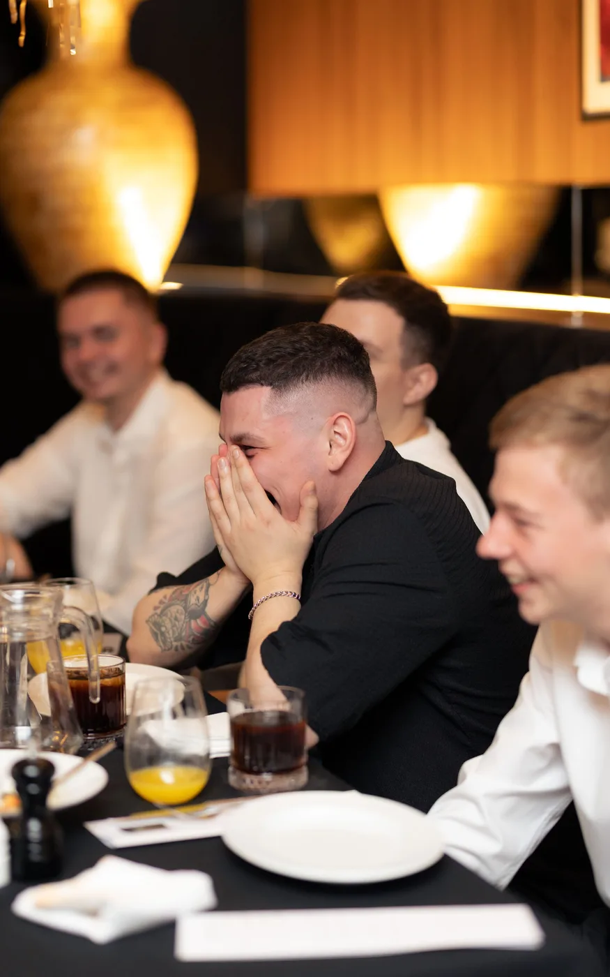 Guests at the celebration table reacting with emotion during the programme